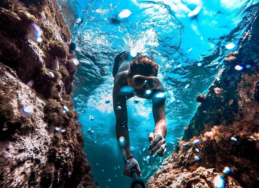 Diver in clean blue bright ocean with goggle