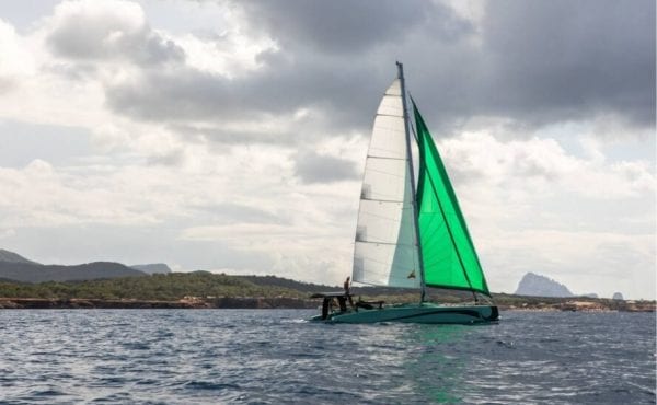 zero-emissions catamaran with green sail on the water