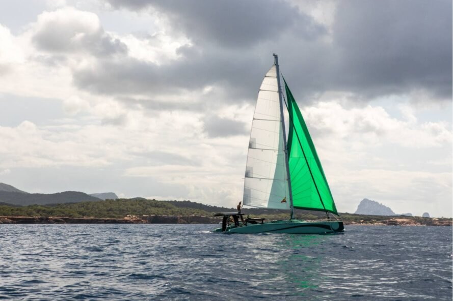 zero-emissions catamaran with green sail on the water