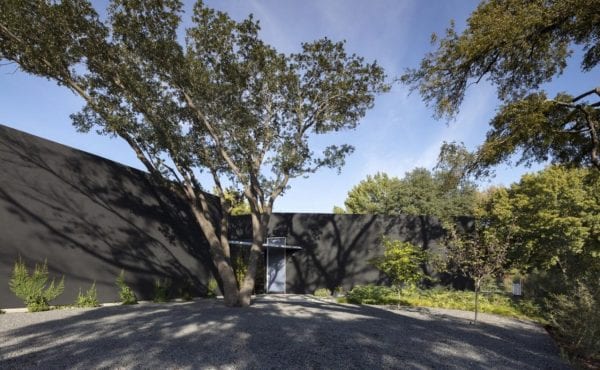 long black home surrounded by trees