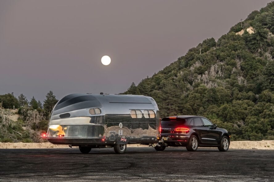 aluminum travel trailer hitched to an SUV