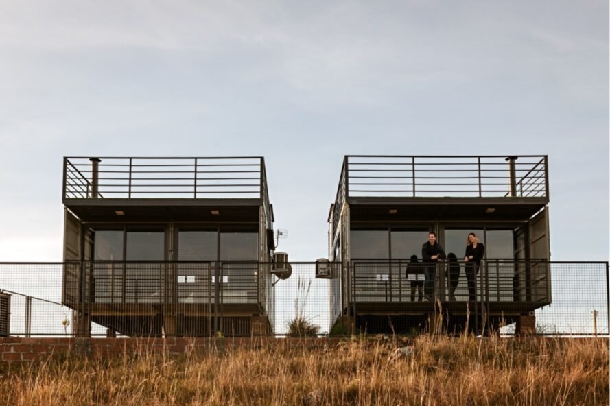 two people on a shipping container home's balcony