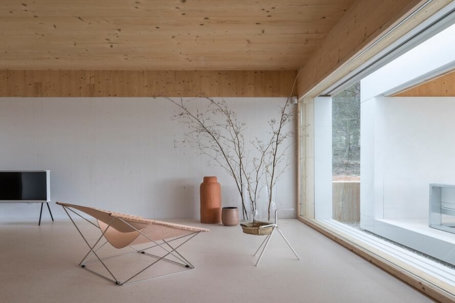 minimalist living space with one chair facing a glass wall