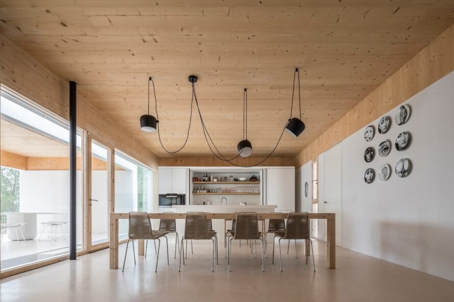 white room with wood ceilings and large wood dining table