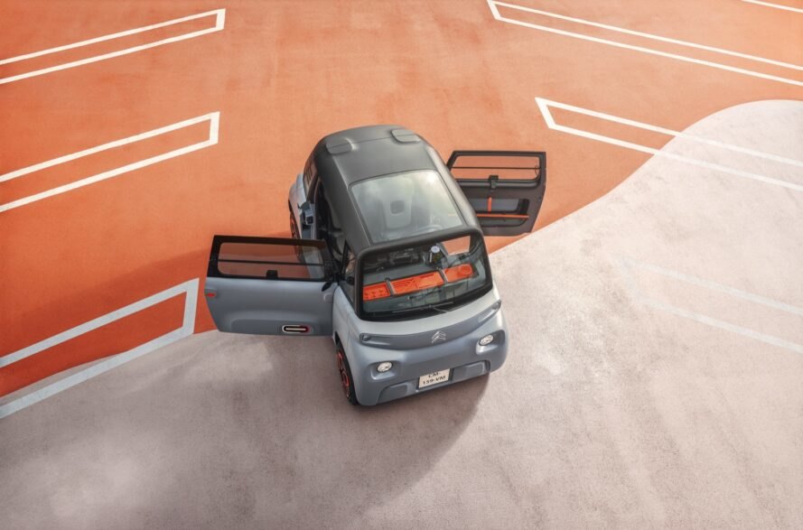 aerial view of tiny gray electric car with open doors